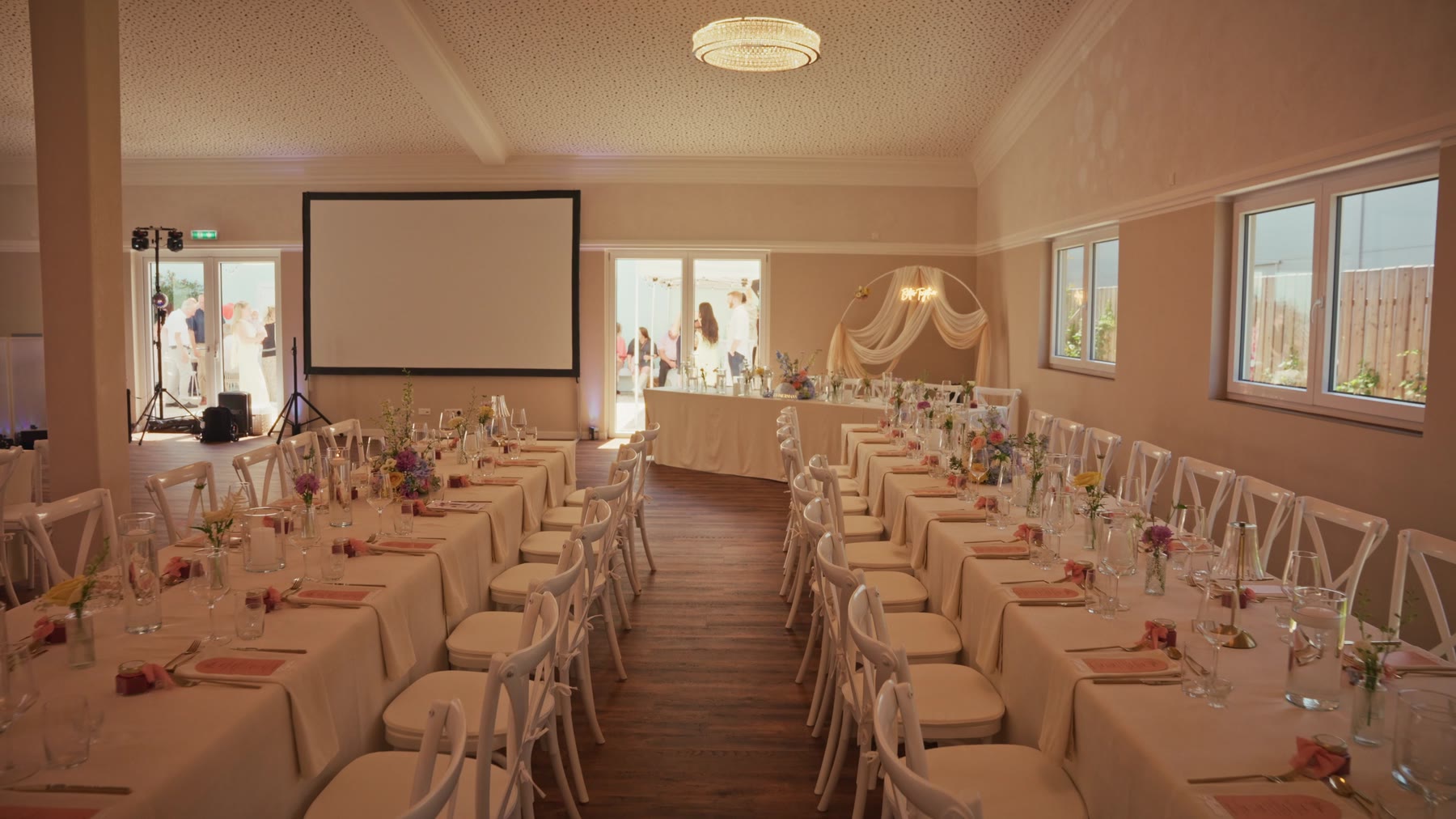Der Saal mit Brauttisch, Stoffbogen und großer Leinwand