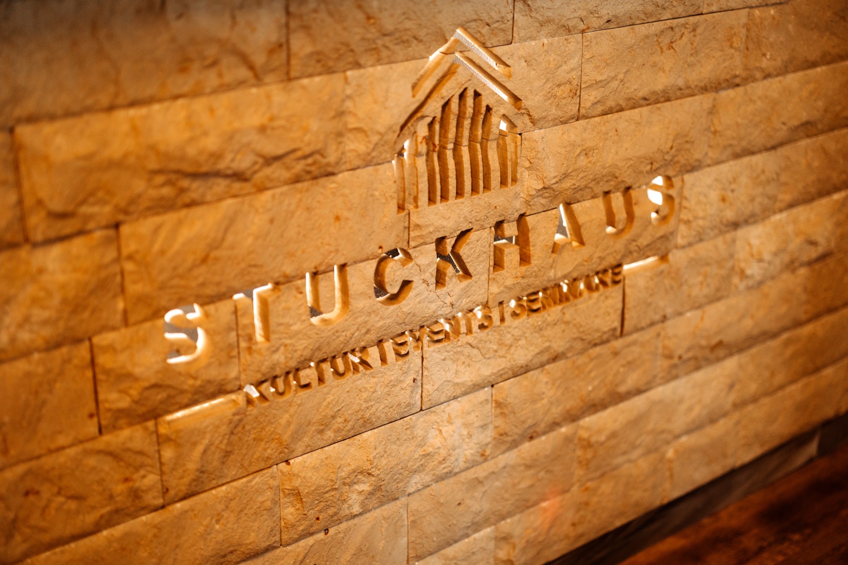 Der Schriftzug Stuckhaus, in die Natursteinwand eingelassen und hinterleuchtet